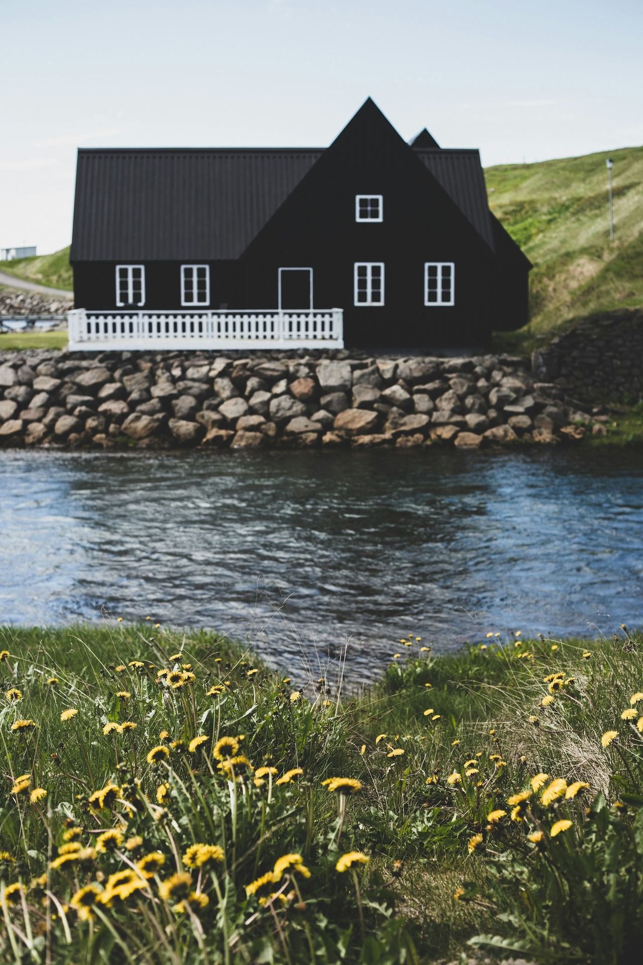 brown wooden house near body of water during daytime